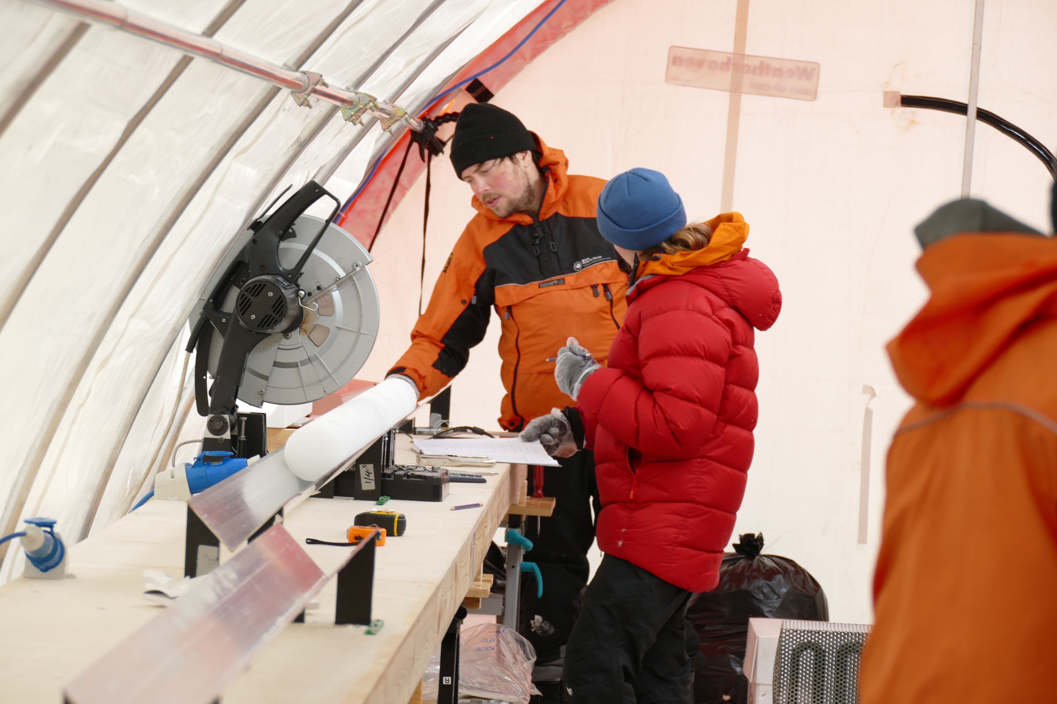 Former Darwin Research Associate Christoph Nehrbass-Ahles and his colleague Mackenzie Grieman cutting an ice core at Skytrain Ice Rise, Antarctica. Photo Credit: Eric Wolff